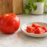 Illustration of a ripe red tomato and pieces without stems or leaves