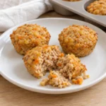 Small savory turkey muffins and broken pieces on a white plate beside a silicone mini-muffin tray.