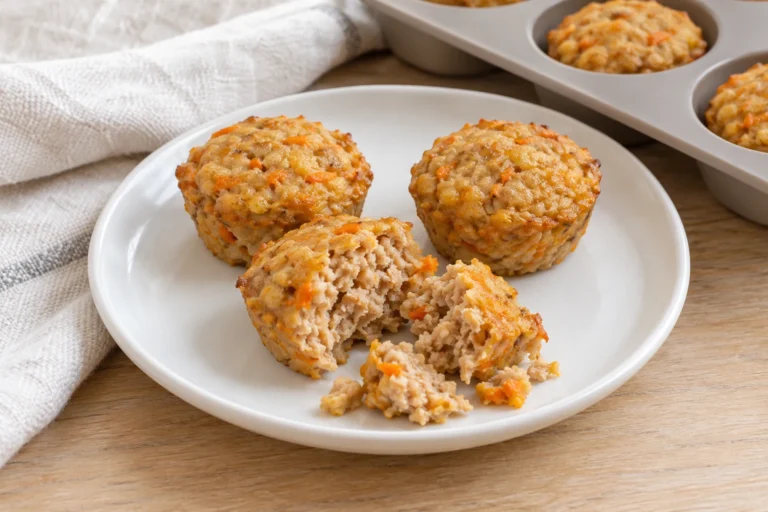 Small savory turkey muffins and broken pieces on a white plate beside a silicone mini-muffin tray.